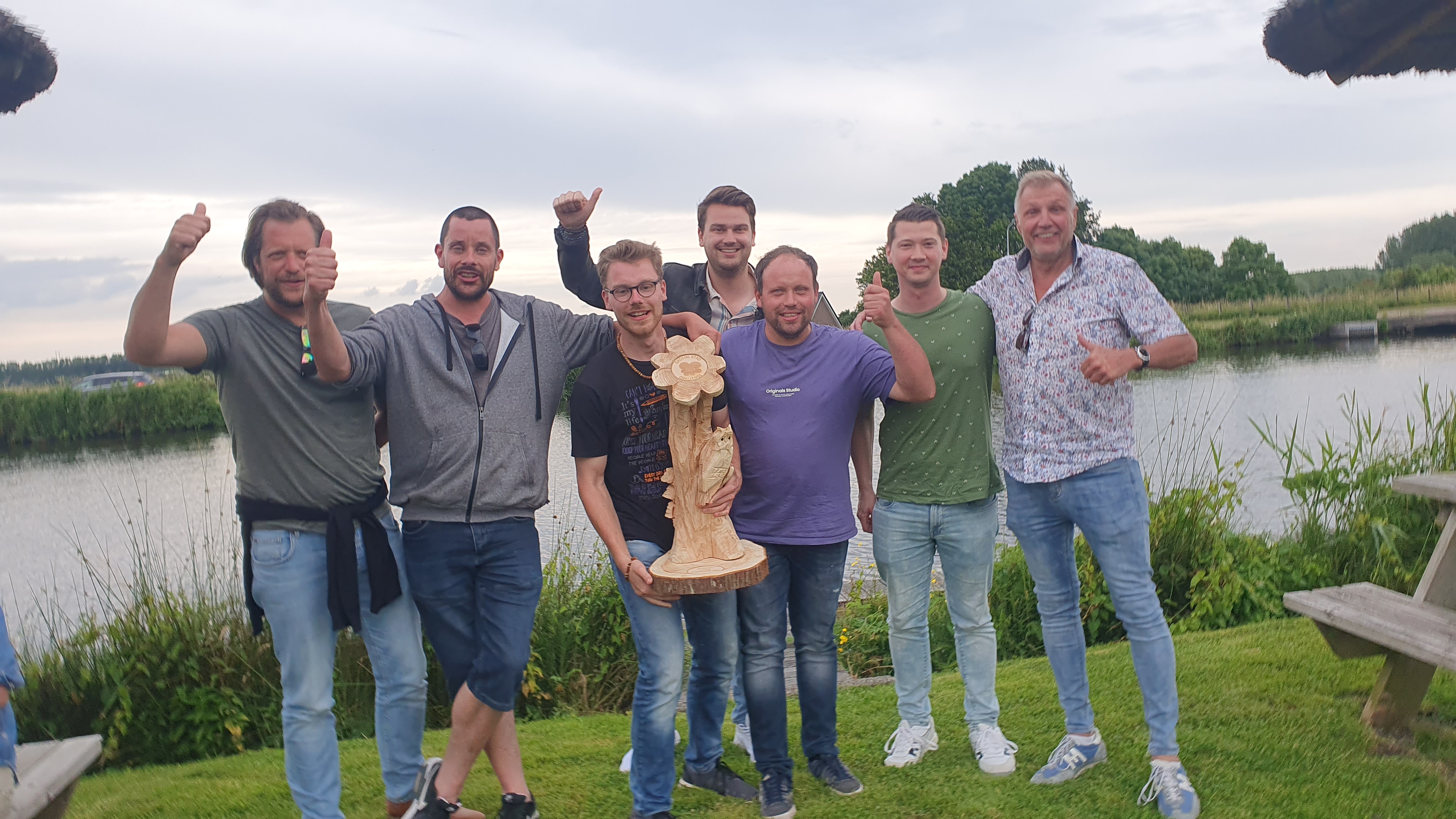 De beker van de Groene Stad Challenge, gemaakt uit hout. Vastgehouden door de twee wethouders en een aantal collega's.